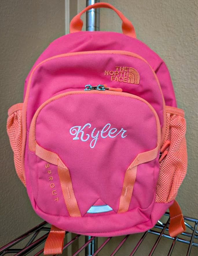 Pink North Face backpack with the name 