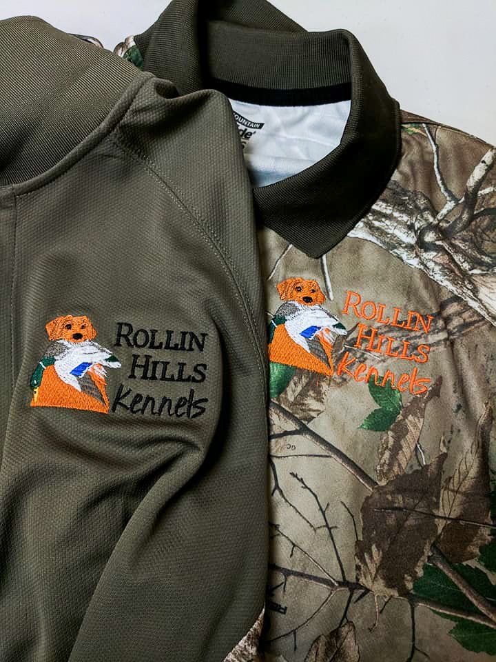 Two shirts, one solid green, one camo, with embroidered 