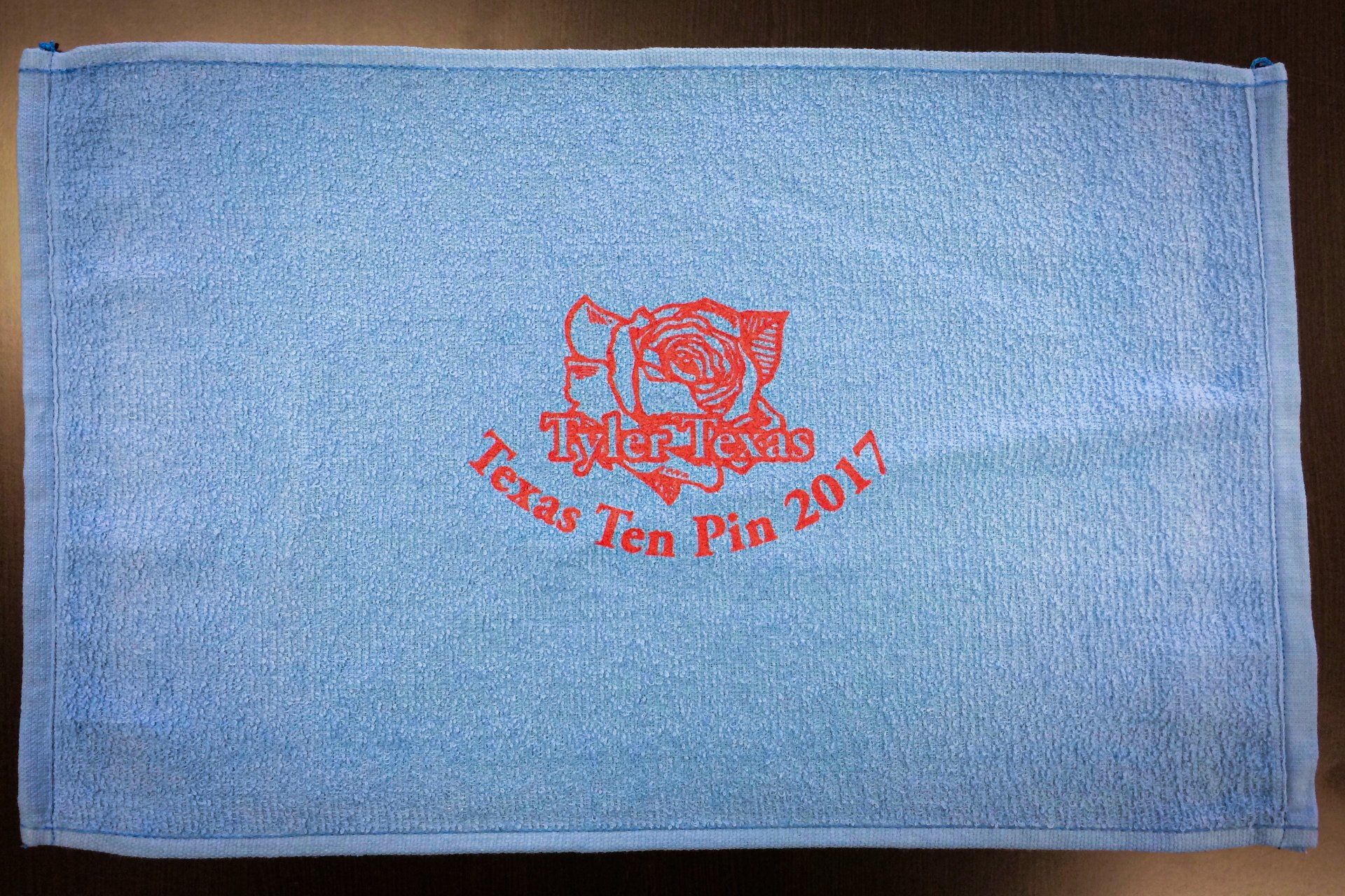 Blue microfiber towel with embroidered red Texas Ten Pin 2017 logo.