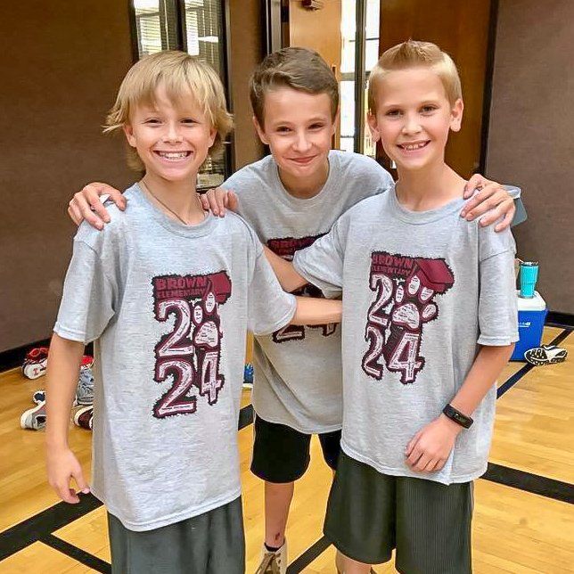 Three boys wearing gray shirts with 