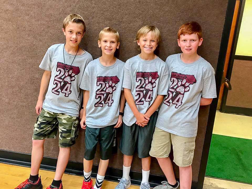 Four boys in matching gray shirts with 