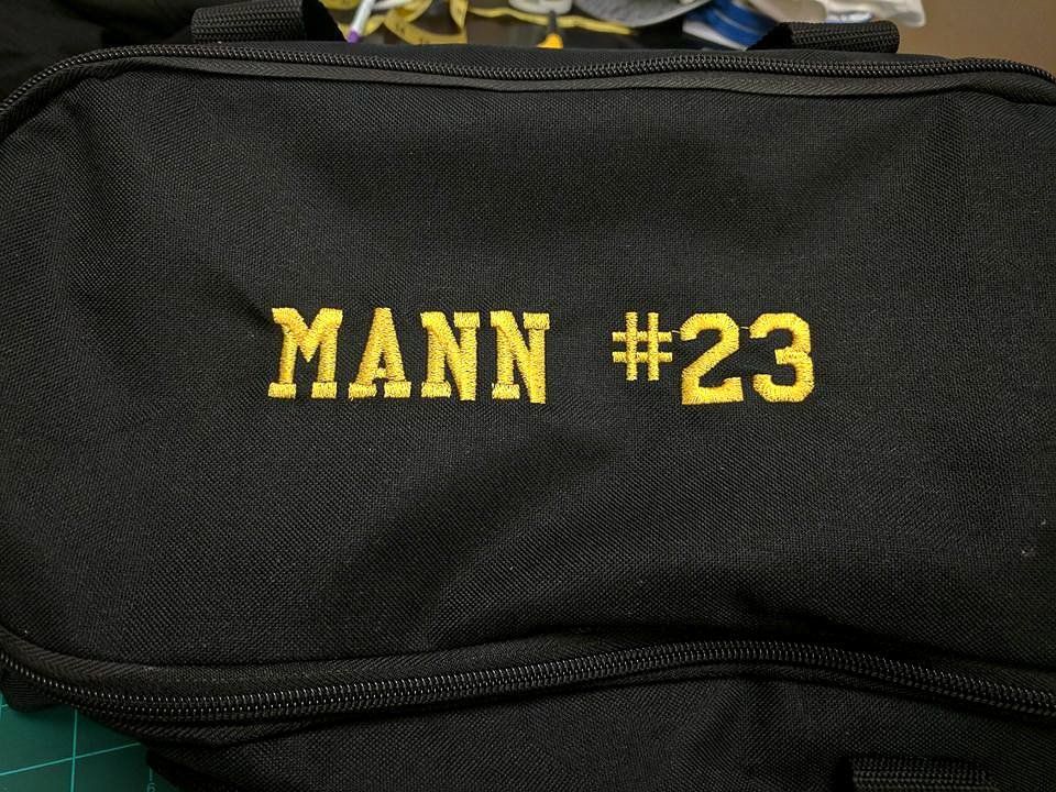 Black bag with yellow embroidered text: 