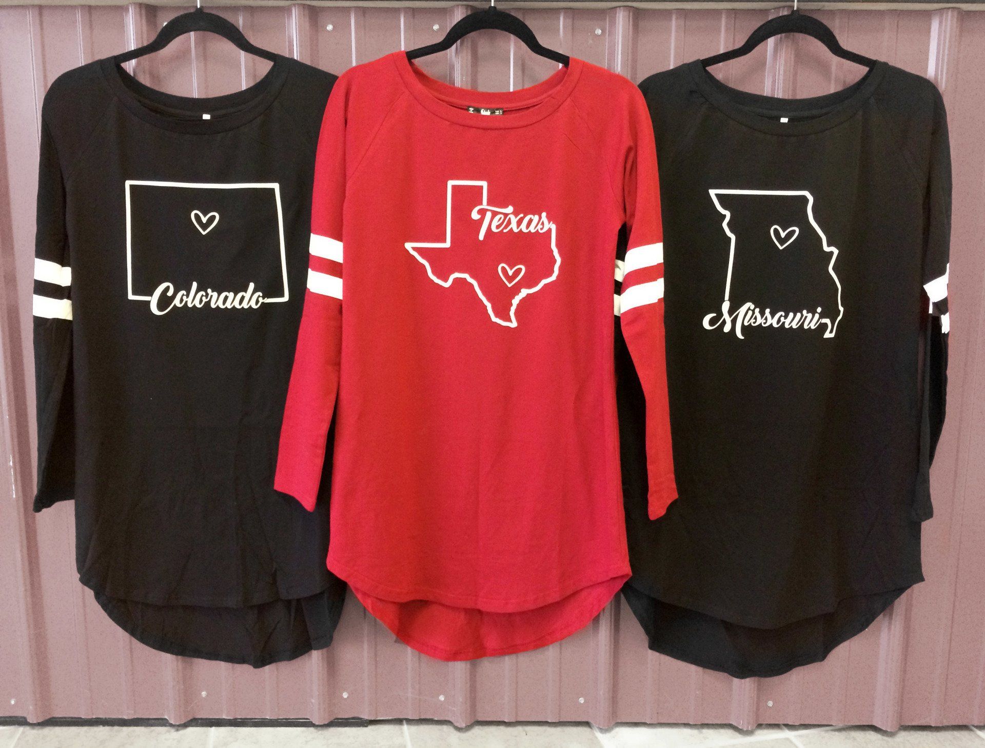 Three long-sleeved shirts: black with Colorado and Missouri outlines, red with Texas outline