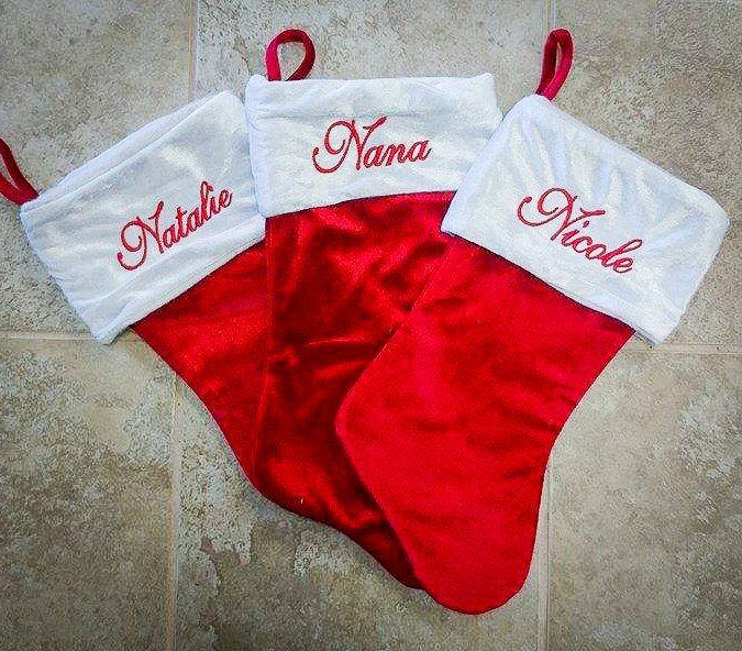 Red Christmas stockings with white cuffs embroidered with the names 
