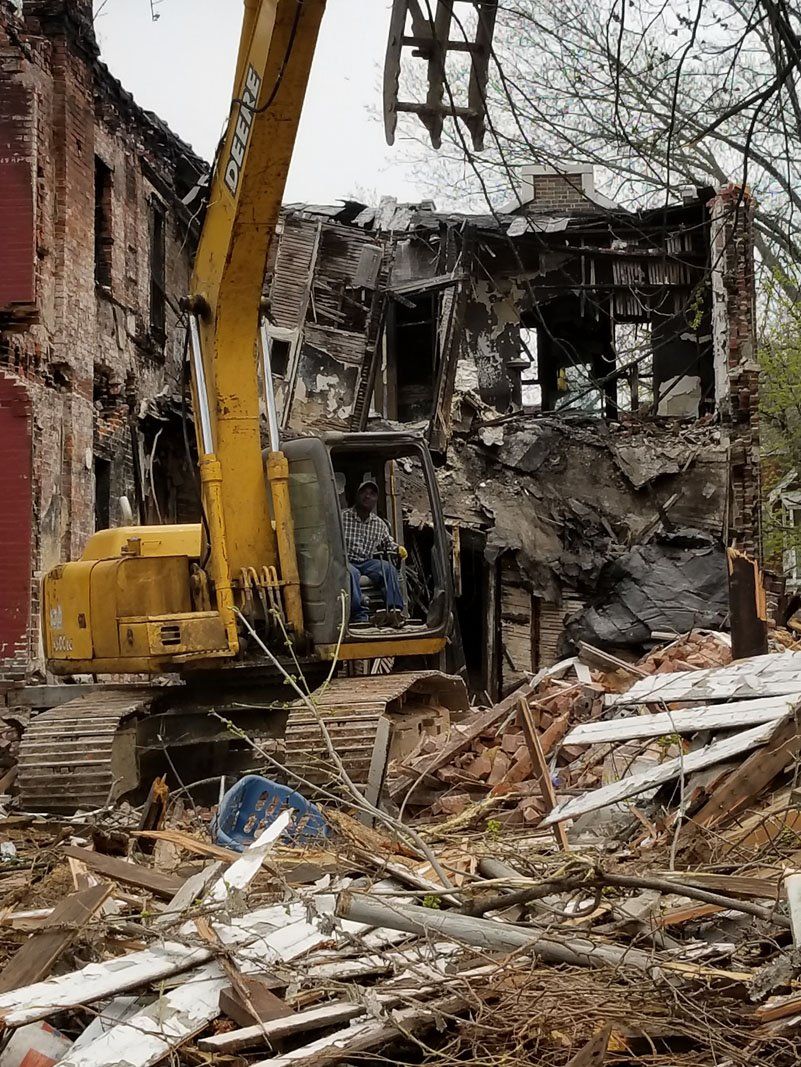 building being demolished with the help of machine