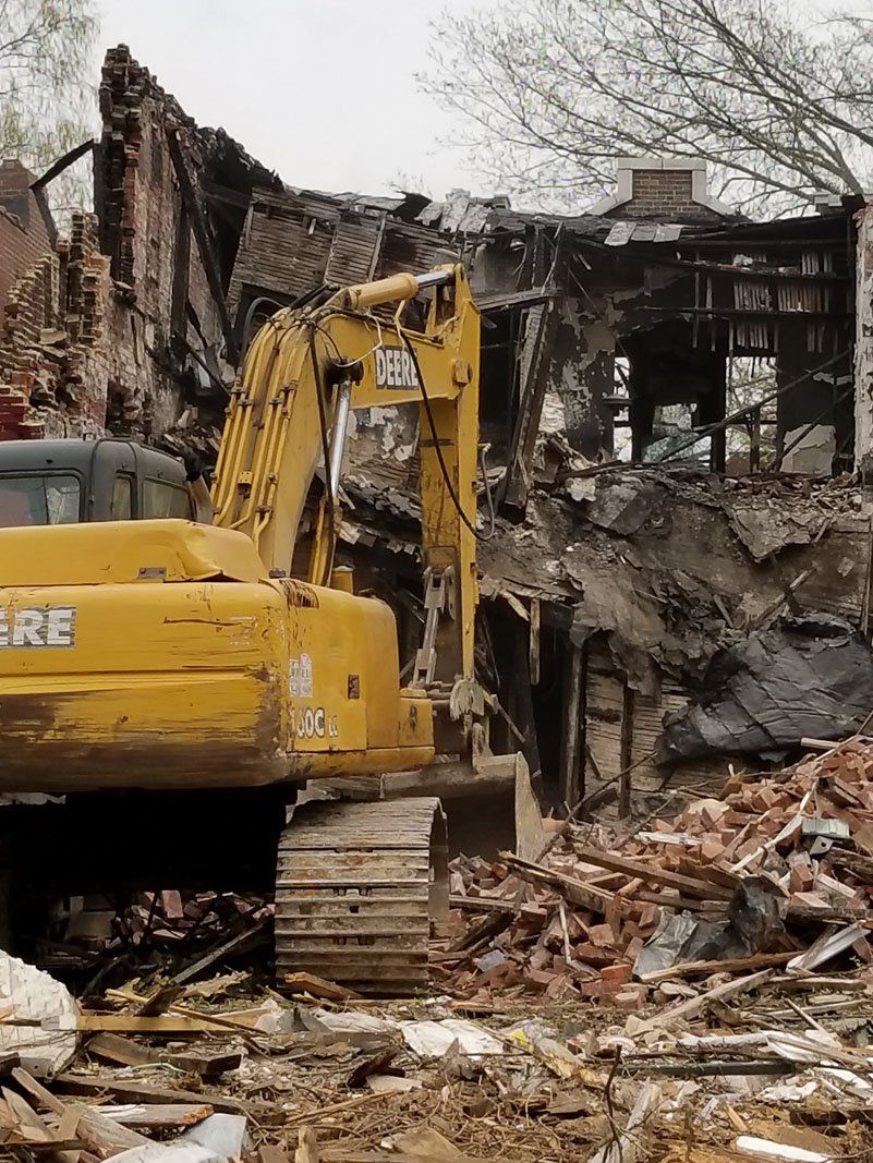building being demolished with the help of machine
