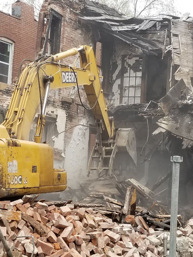 building being demolished with the help of machine
