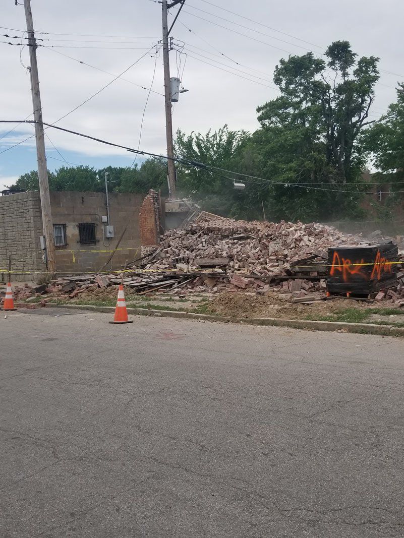 building being demolished with the help of machine