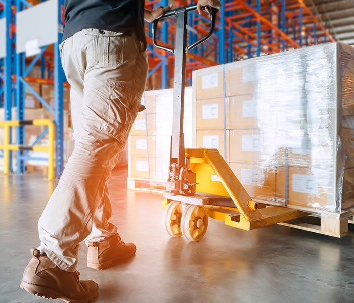 Worker Holding Pallet Truck — Piscataway, NJ — Central Forklift Inc. Worker Holding Pallet Truck — Piscataway, NJ — Central Forklift Inc.