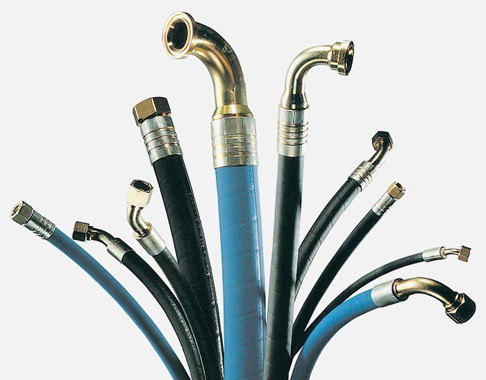 A bunch of different types of hydraulic hoses on a white background