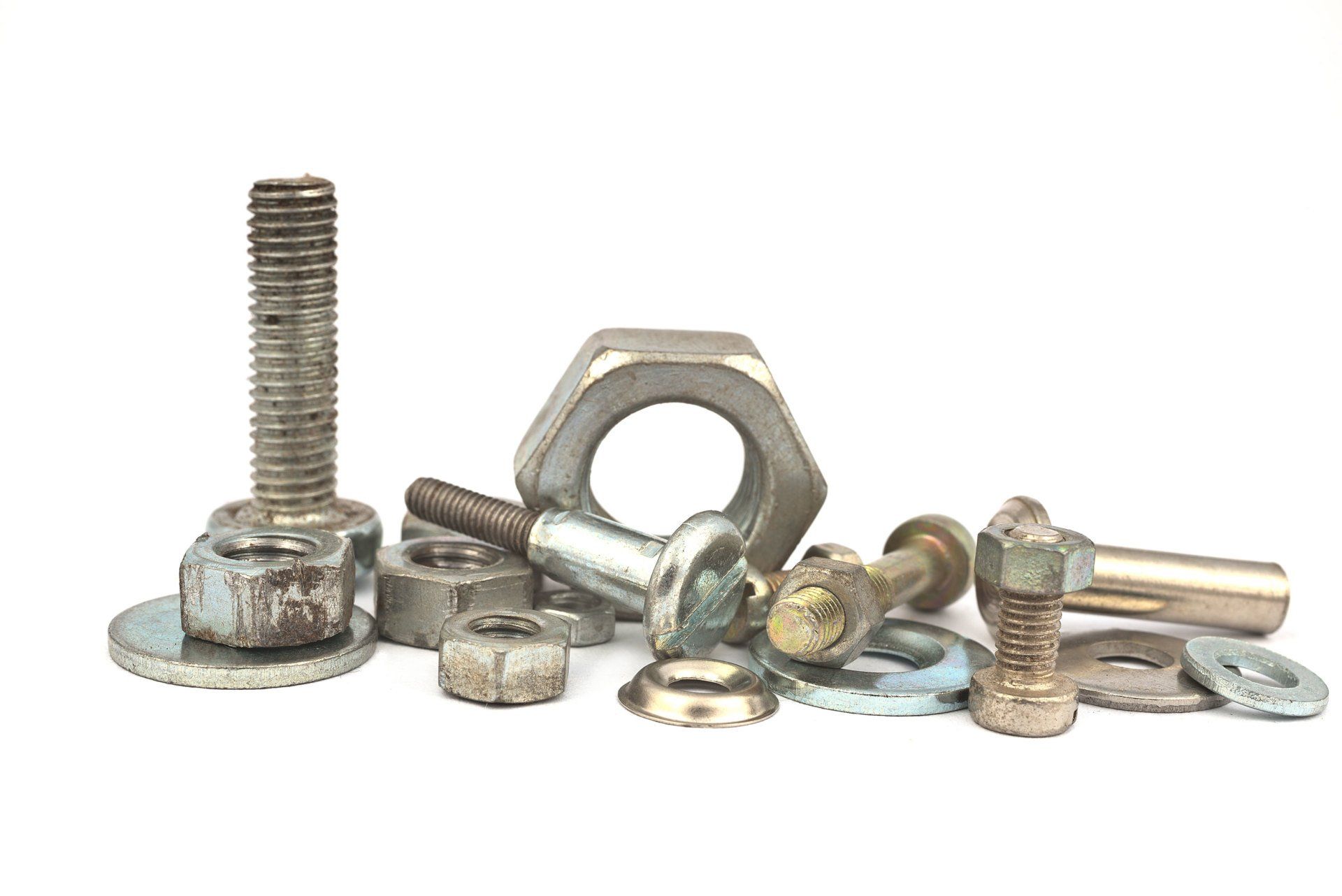 A pile of nuts , bolts , washers and screws on a white background.