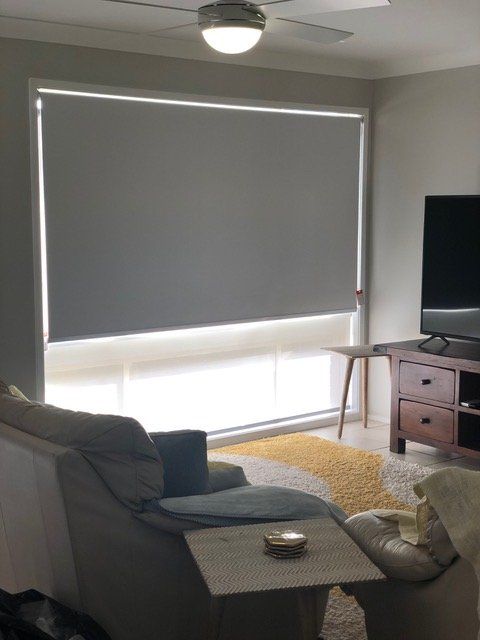 A living room with a couch and a television — Plantation Shutters in Singleton, NSW