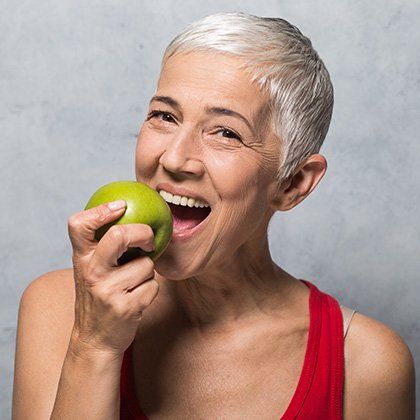 elder woman eating apple