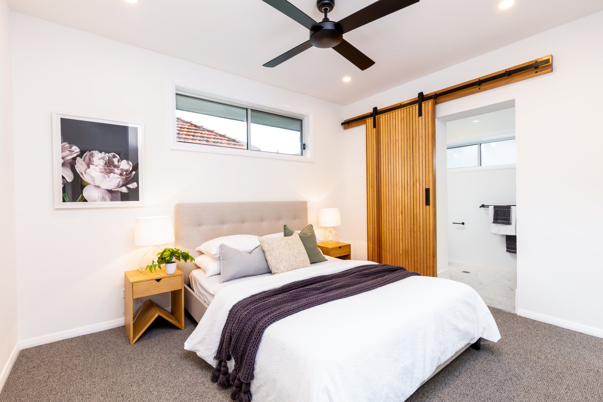 Bedroom with bed, wooden sliding door, and a window.