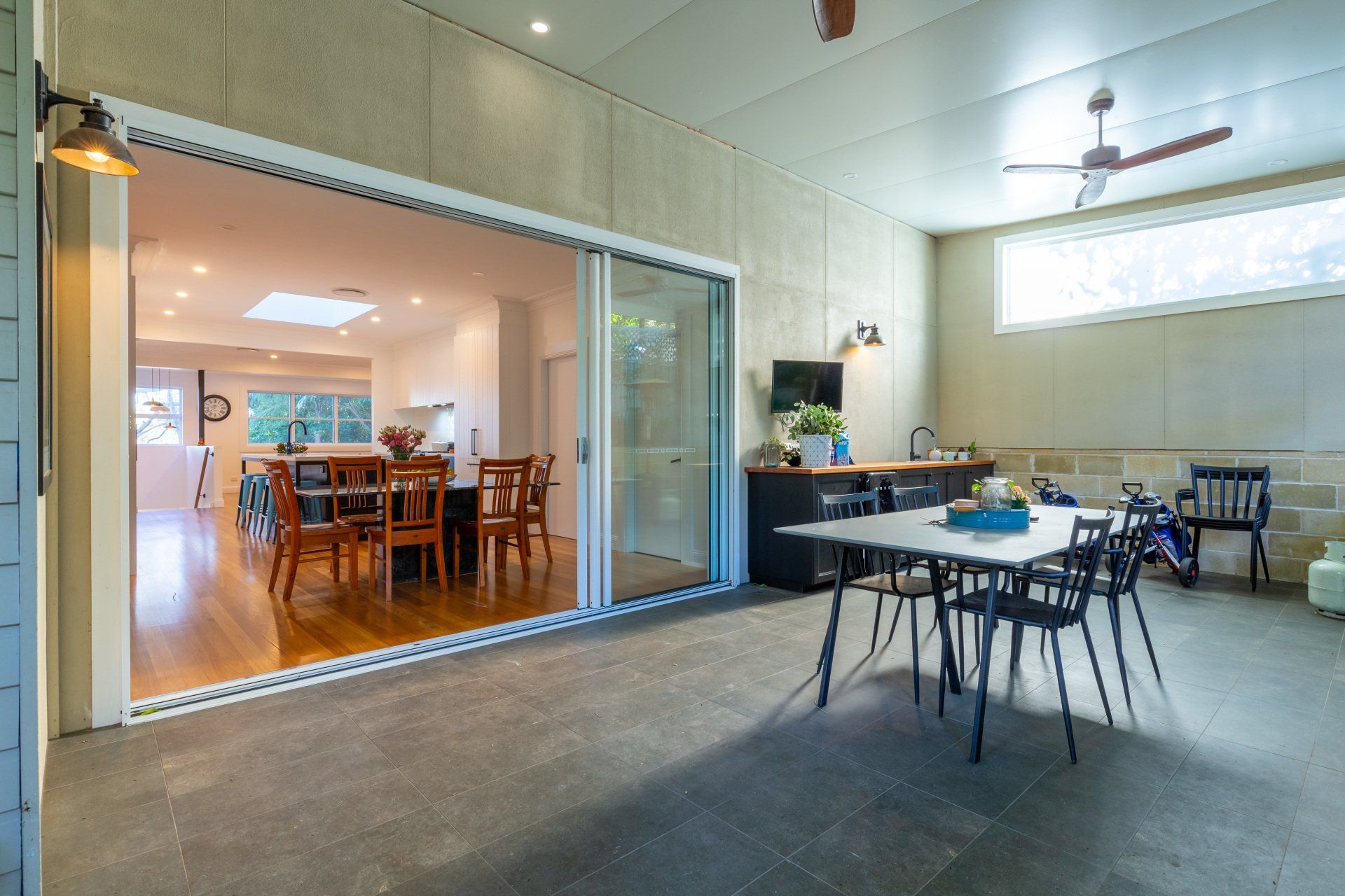 Patio with dining table, outdoor kitchen, and sliding glass door to interior kitchen.