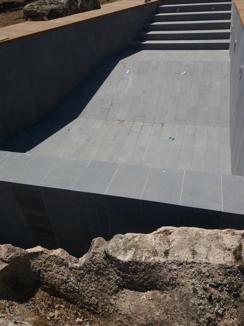 piscina con rivestimento in pietra scura