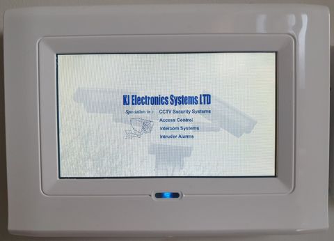 Small intruder alarm unit on a wall by a door