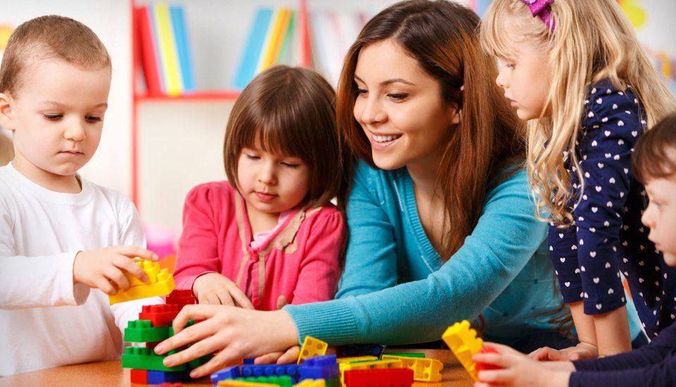 A nanny playing lego with children