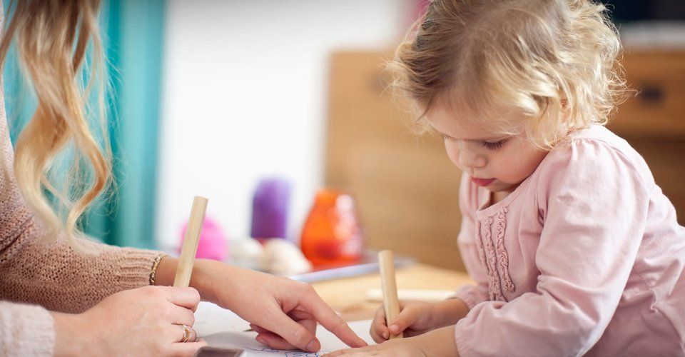 A nanny help a child to write