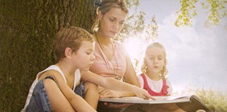 A nanny reading a story to kids