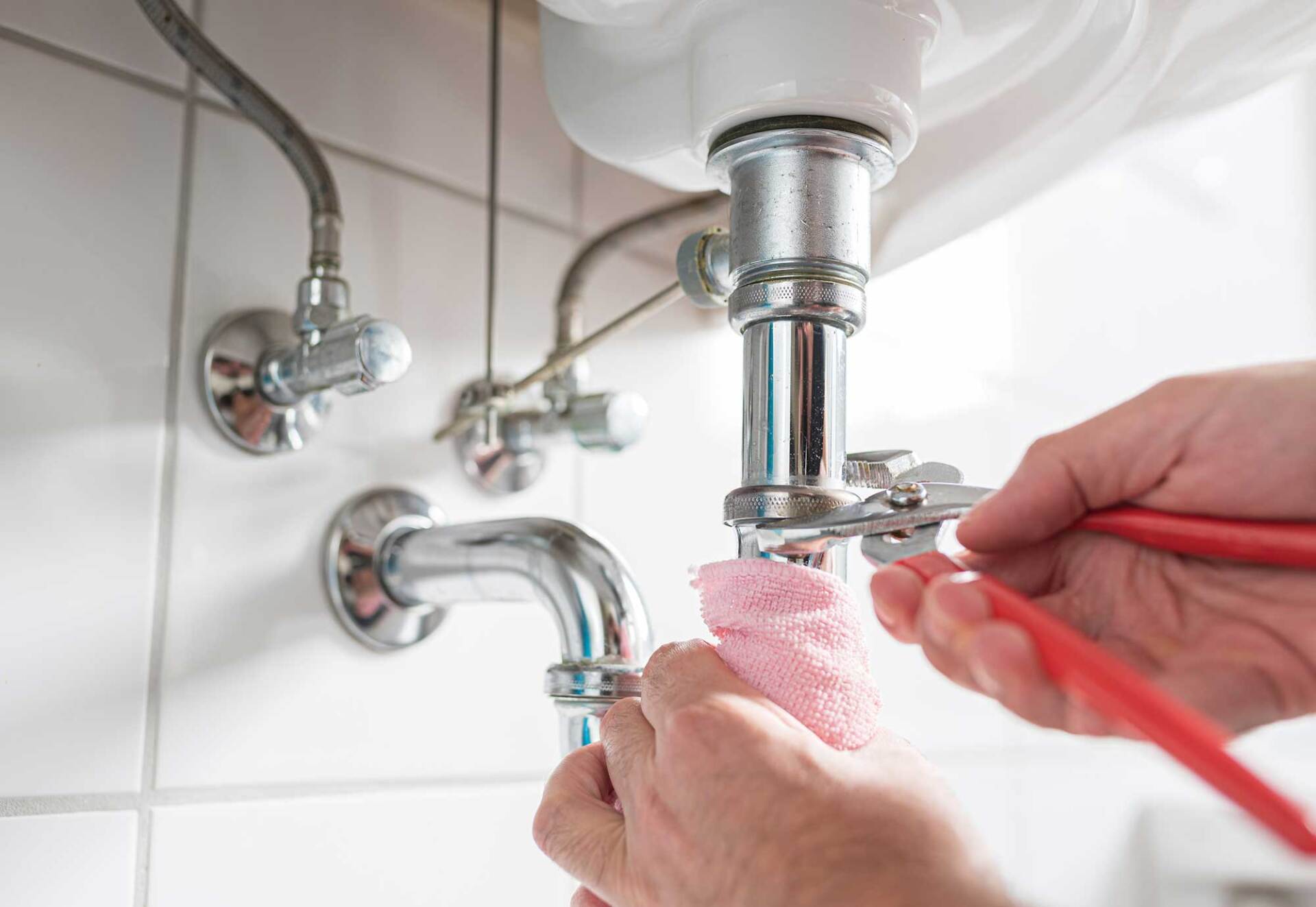 Plumber Repairing Sink Trap with Adjustable Pipe Wrench — Delaware, OH — Wells Septic & Drain Cleaning
