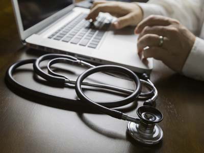 Stethoscope near Man Typing on Laptop Computer - Foot Specialists Of CNY PC Stethoscope near Man Typing on Laptop Computer - Foot Specialists Of CNY PC