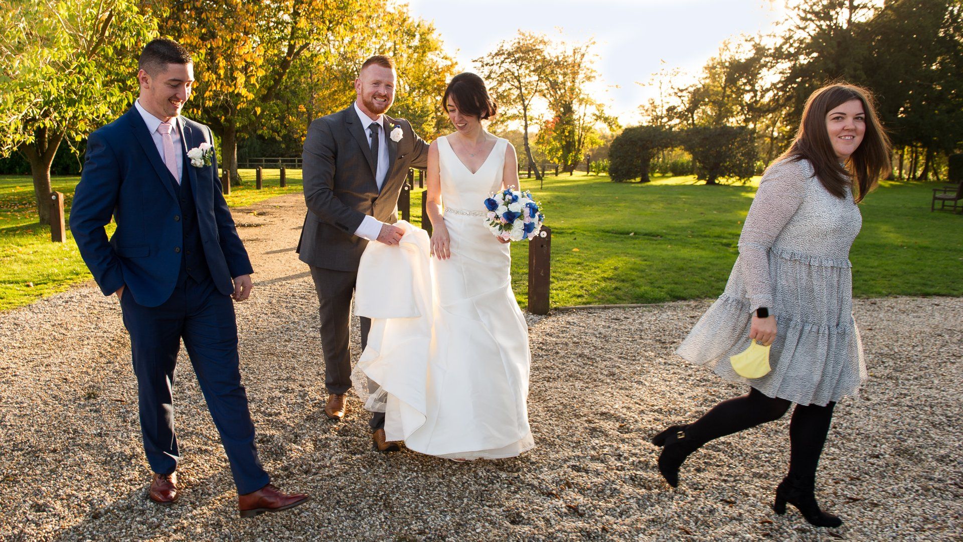 bride and groom walking with their best man and bridesmaid in the the late afternoon winter sun