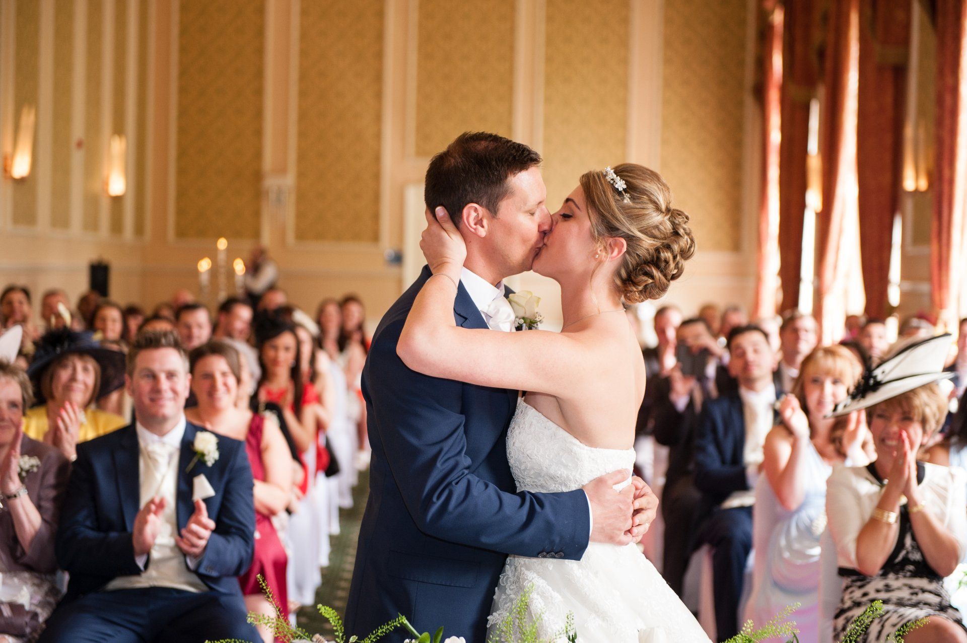 Bride and Grooms first kiss, family and friends clap and cheer