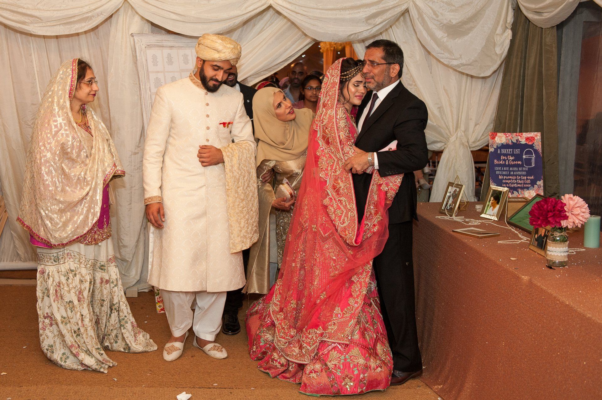 Muslim Bride and father embrace and cry, as she starts her new life living with her husband and family in-law