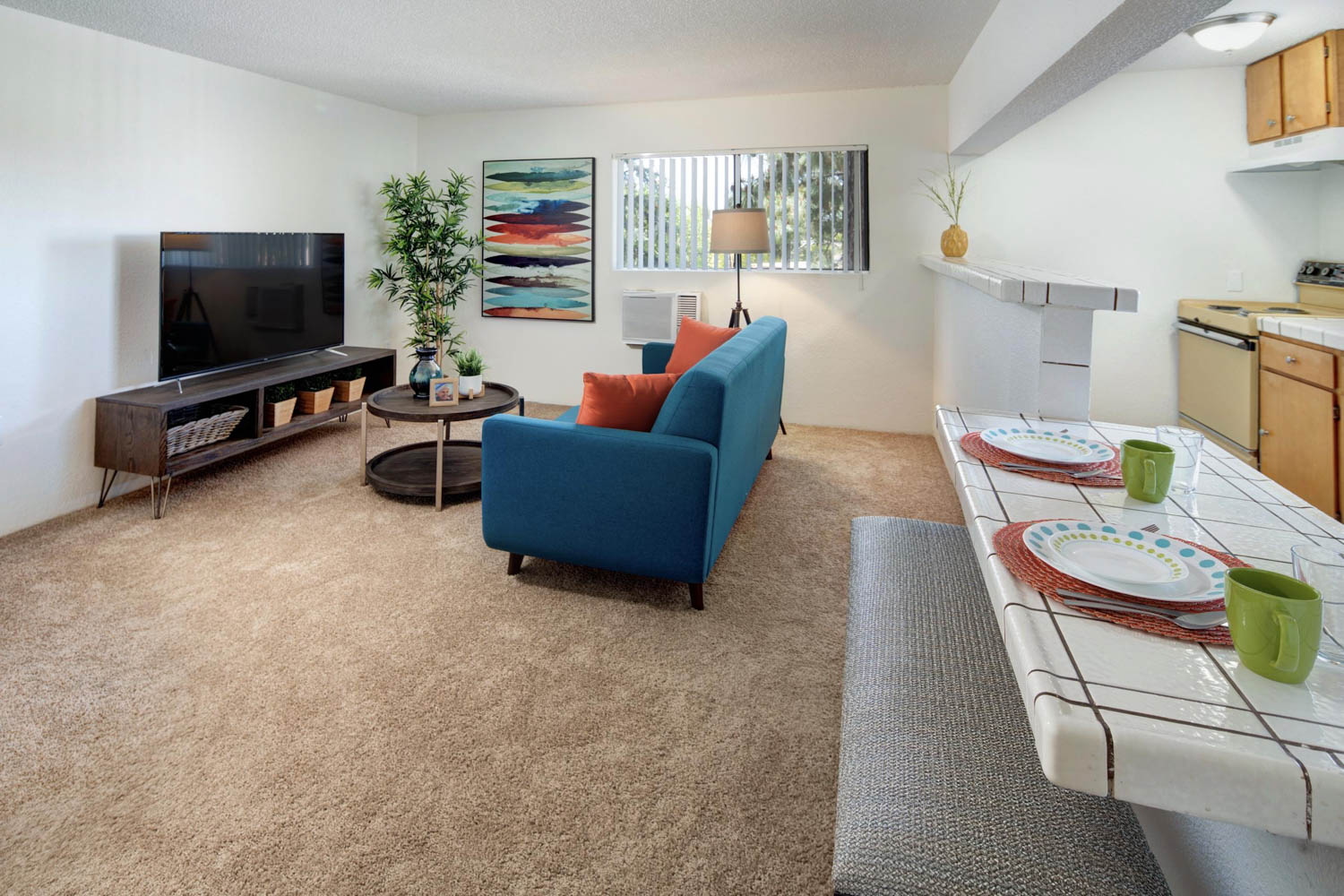 A living room with a blue couch and a flat screen tv.