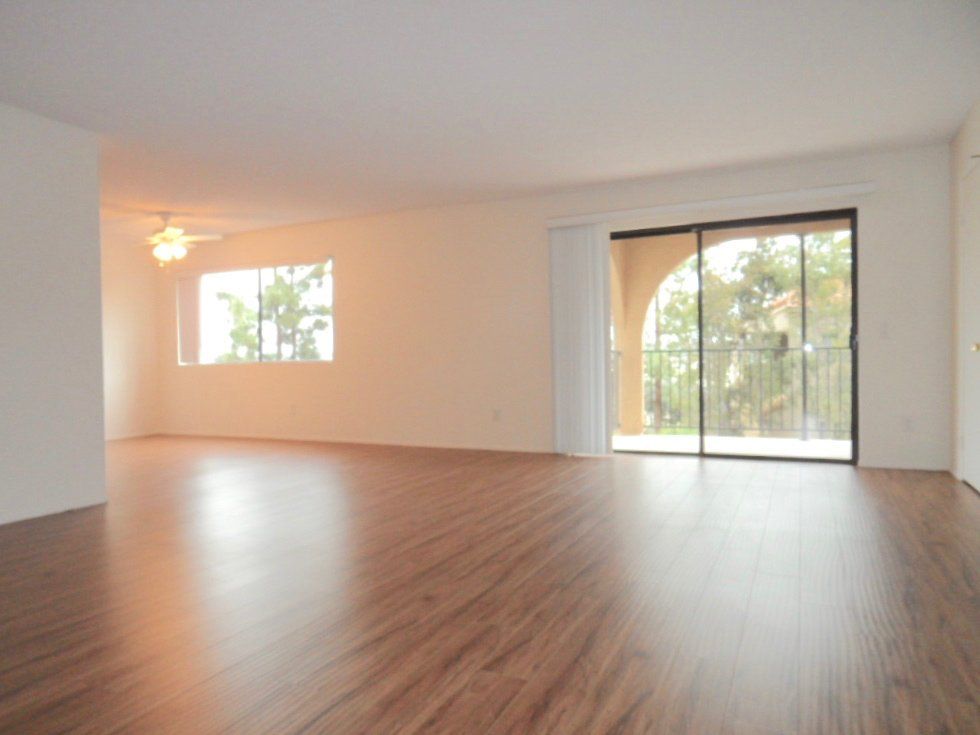 An empty living room with hardwood floors and sliding glass doors