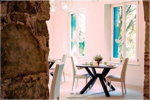 Sala con ingresso in pietra e tavoli in legno apparecchiati