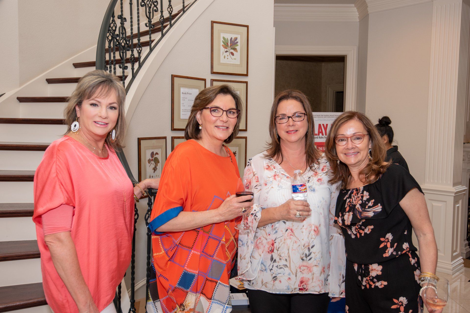 A group of women are posing for a picture in front of a staircase.