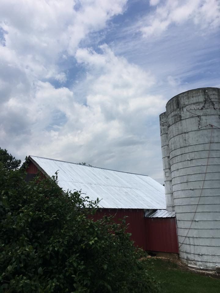 a red barn with a white silo in front of it