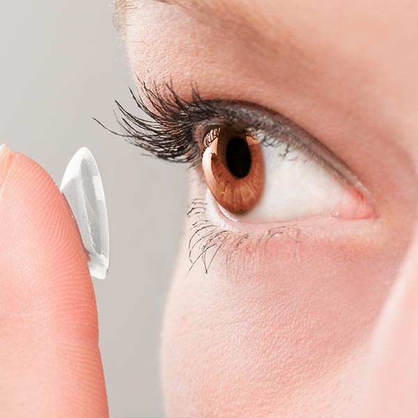 Contact Lenses — Woman Inserting a Contact Lens in Eye in Lawton, OK Contact Lenses — Woman Inserting a Contact Lens in Eye in Lawton, OK