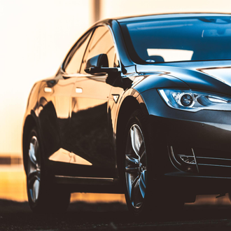 A black car is parked in front of a building