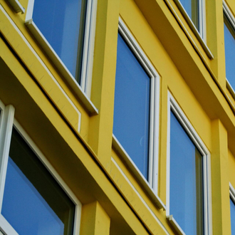 A yellow building with blue windows and white trim