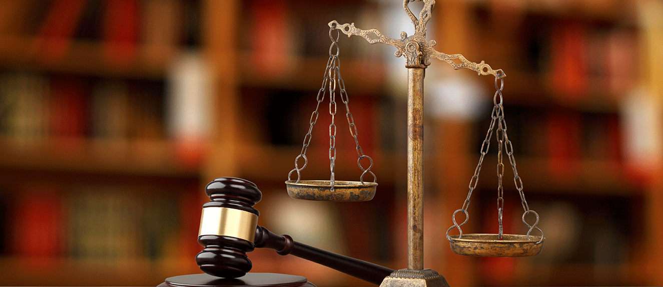 gavel and scale with blurred books in the background