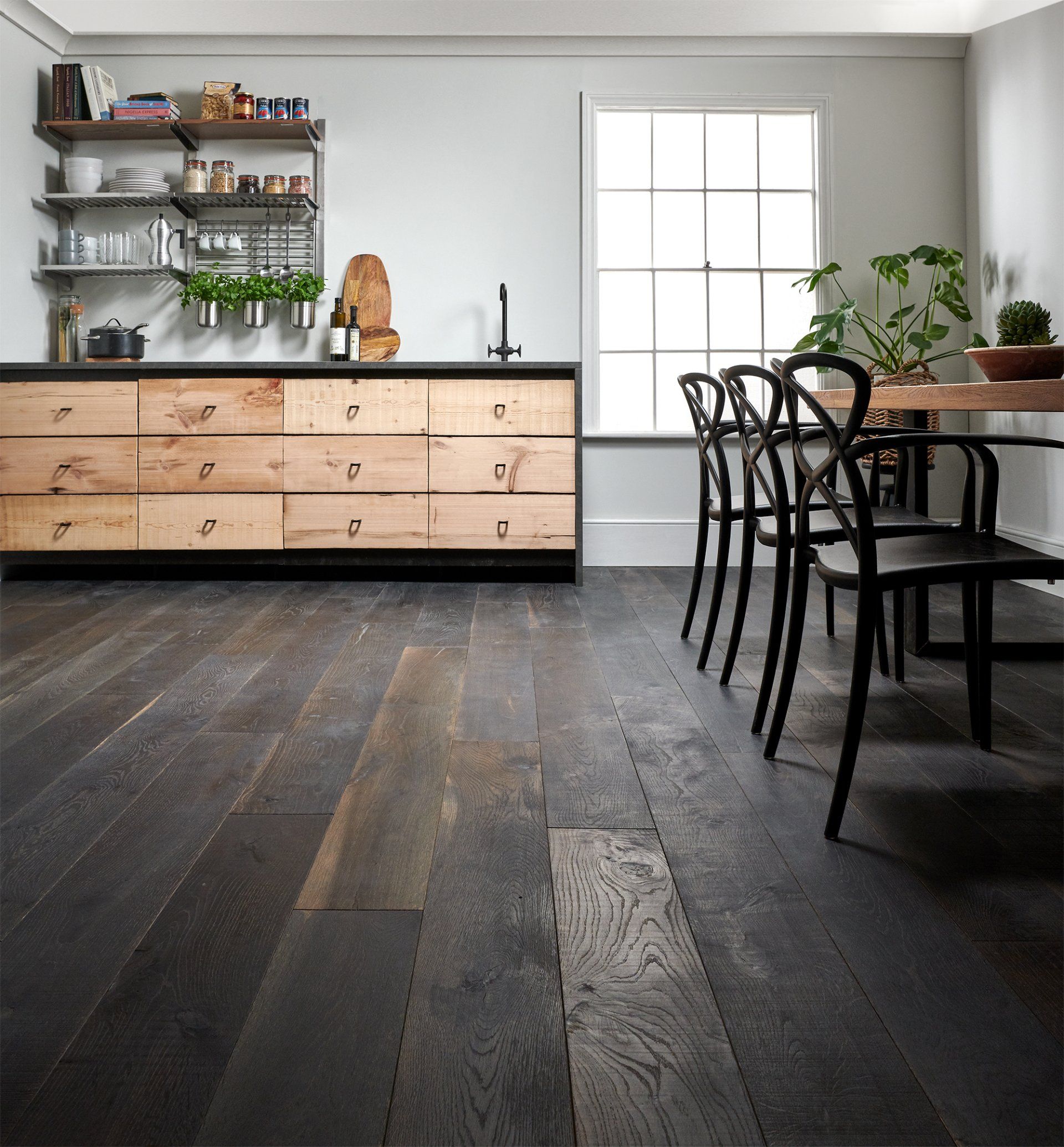 Wooden flooring in a kitchen with wooden drawers and a table and chairs