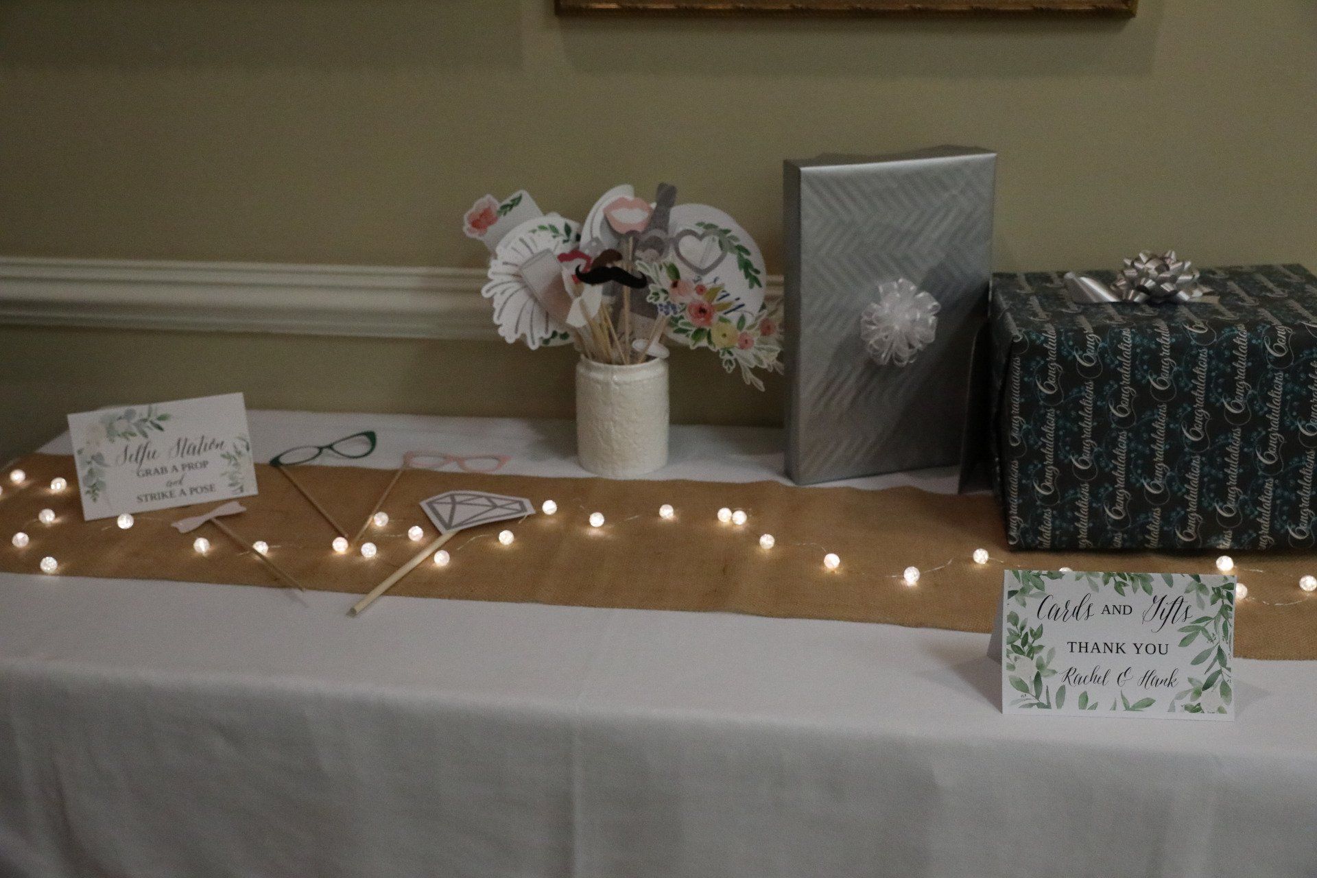Table display with gifts, paper decorations, and fairy lights.