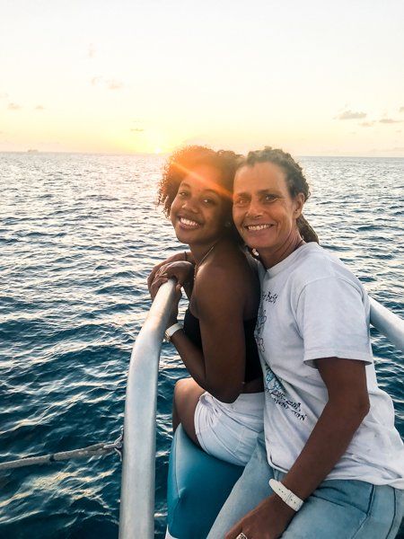 Two women sitting at the front of the Random Wind Yacht during a sunset