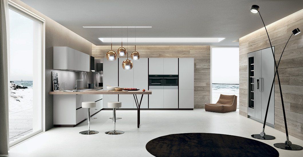una cucina angolare e delle lampade a sospensione