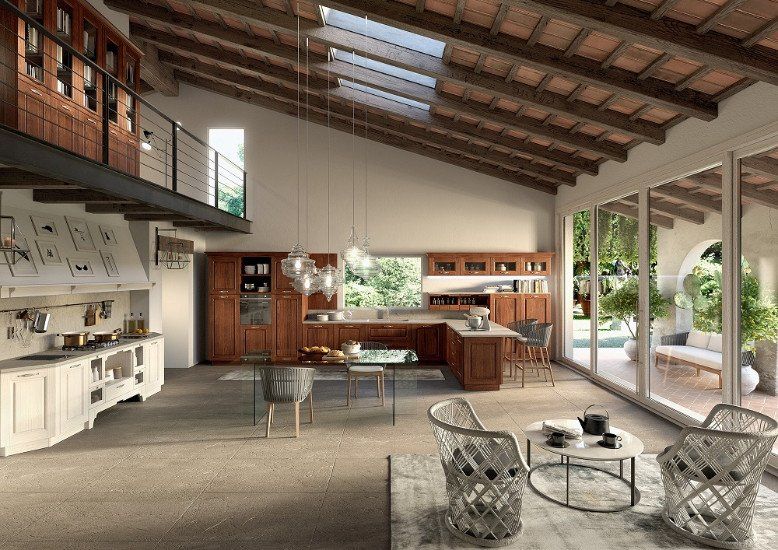 una cucina grande con dei mobili in legno chiaro e di color bianco