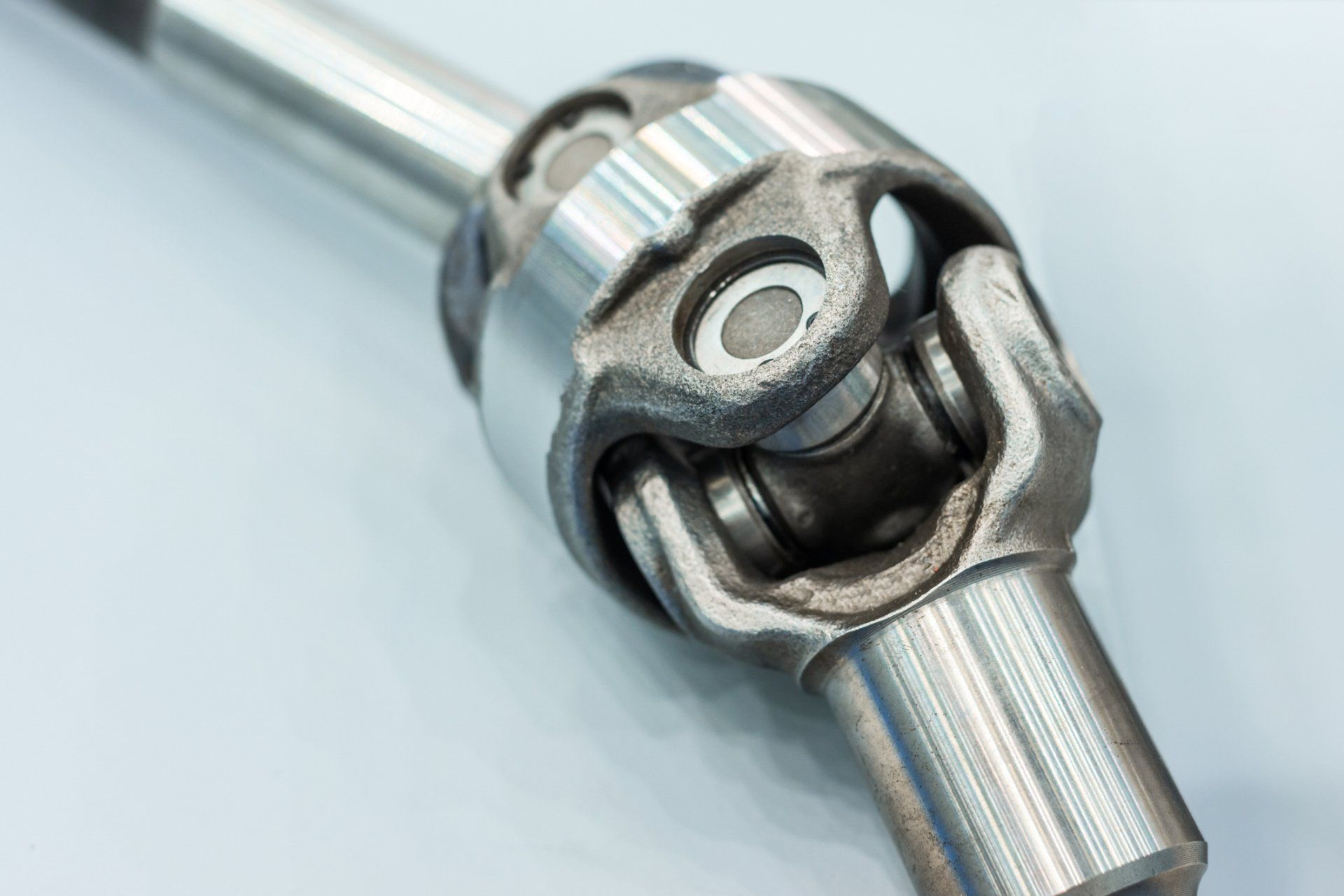 A close up of a metal joint on a white surface.