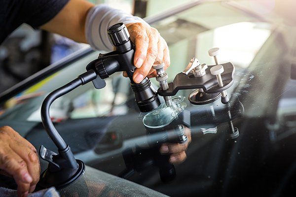 Broken Car Glass Being Repaired Using Professional Equipment — Converse, TX — Quality Master Auto Glass