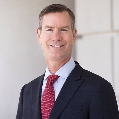 A man in a suit and tie is smiling for the camera.