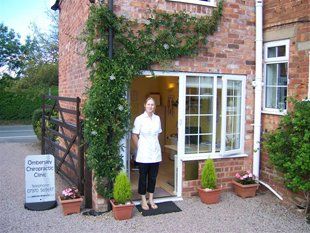 A woman is standing in front of a brick building
