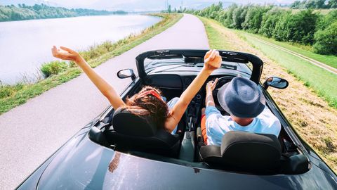 two tourists in hired convertible car