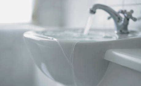 a sink overflowing due to leaky taps