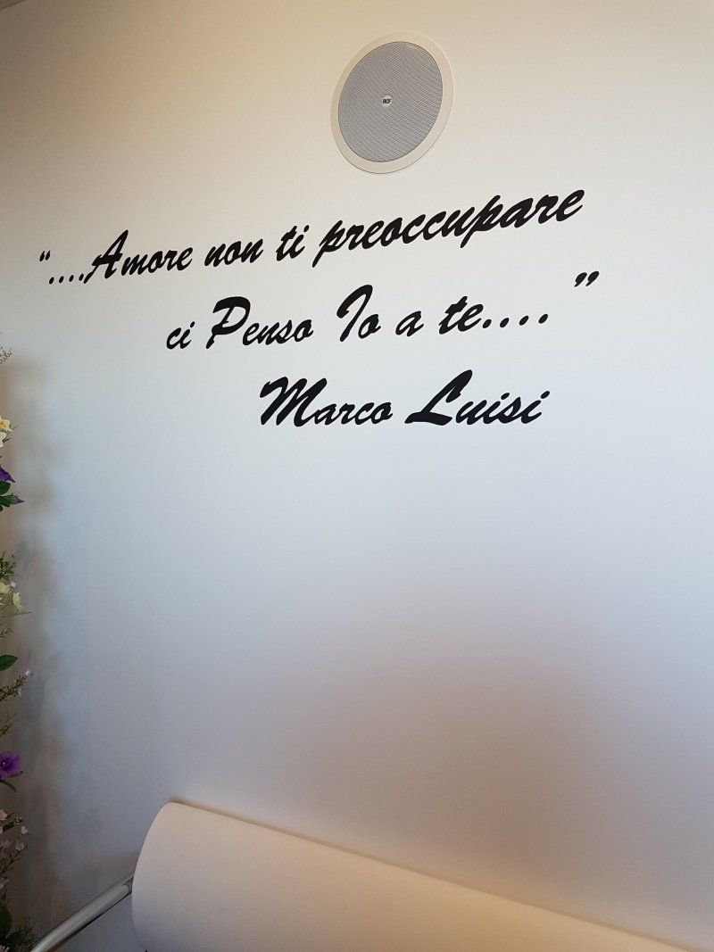 White wall with Italian quote in black lettering: